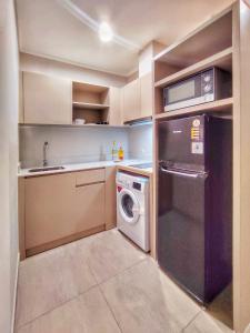 a small kitchen with a washer and dryer in it at BRAND NEW 2BR Apt Menara Jakarta, Jkt Inter Expo in Jakarta