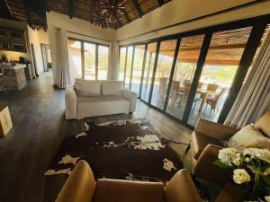 ein Wohnzimmer mit einem Sofa und einem Tisch in der Unterkunft Bush Villa Ditholo 51 in Mmukubyane