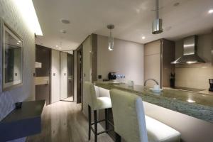 uma cozinha com um bar com cadeiras e um balcão em Livbnb - City Center Studio close to Everything em Dubai