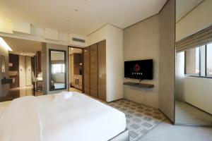 a hotel room with a bed and a flat screen tv at Livbnb - City Center Studio close to Everything in Dubai