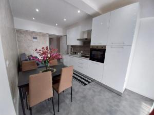 een keuken met witte kasten en een tafel met stoelen bij PENSIUNEA IDEAL in Băile Borşa