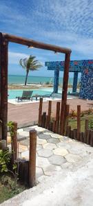 a stone walkway leading to a beach with a palm tree at Estância Pedacinho do Céu Prado Bahia in Prado +33 photos