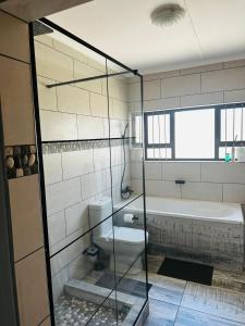 een badkamer met een douche, een bad en een toilet bij Euphorie in Walvis Bay