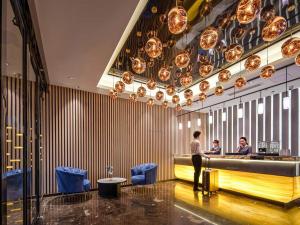 a man standing at a bar in a restaurant at Park Inn by Radisson Chongqing Yuelai International Expo Center in Chongqing