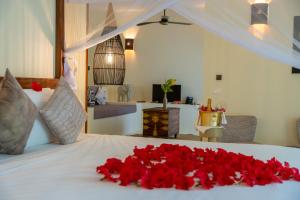 Alma Boutique Hotel في جامبياني: سرير عليه باقة ورد حمراء