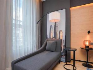 a living room with a couch in front of a window at Park Inn by Radission Tianjin Binhai International Airport in Tianjin