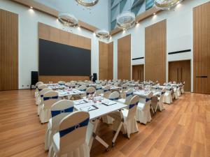 a large room with tables and chairs and a screen at Park Inn by Radisson Shanghai Shanghai Middle Jiasong Road Outlets in Qingpu