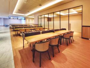 a cafeteria with wooden tables and chairs in a building at BRAND NEW 2BR Apt Menara Jakarta, Jkt Inter Expo in Jakarta