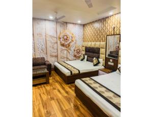 una camera d'albergo con due letti e una sedia di Hotel Sita Niwas Since 1965, Amritsar ad Amritsar