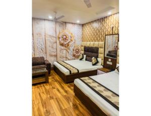 a hotel room with two beds and a chair at Hotel Sita Niwas Since 1965, Amritsar in Amritsar