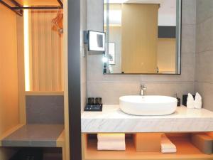 y baño con lavabo y espejo. en Park Inn by Radisson Jilin Beishan Park&Songhua River, en Jilin