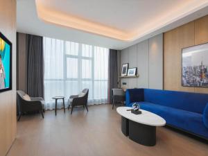 a living room with a blue couch and a table at Park Inn by Radisson Nanchong Yilong Star City Plaza in Yilong