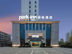 a park inn beijing building with a sign on it w obiekcie Park Inn by Radisson Hanzhong Central Square & High speed rail station w Hanzhong