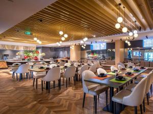 a restaurant with tables and chairs in a room at Park Inn by Radisson Tongling The City Core in Tongling