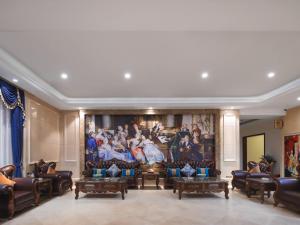 a living room with a large painting on the wall at Vienna International Hotel FuJian PuTian Pearl in Putian