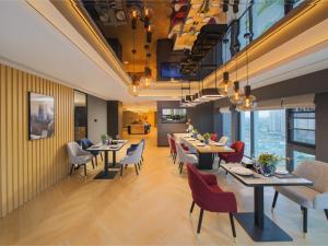 a restaurant with tables and chairs in a room at Park Inn by Radisson Chengdu FengHuang Mountain Sports Park in Xindu