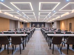 a large room with tables and chairs and a screen at Park Inn by Radisson Tongling The City Core in Tongling