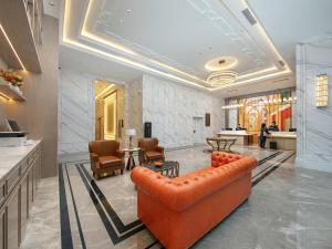 a living room with a leather couch and chairs at Vienna International Hotel Chengdu Shuangliu Airport Terminal Beijing Hualian in Chengdu