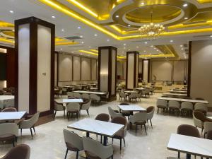 een eetkamer met tafels en stoelen en een kroonluchter bij Vienna International Hotel Shanghai Hongqiao Airport Convention and Exhibition Center Huaxu Highway in Qingpu