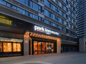 a building with a sign on the front of it at Park Inn by Radisson Chengdu FengHuang Mountain Sports Park in Xindu