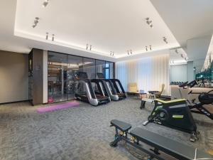 a gym with treadmills and exercise equipment in a building at Park Inn by Radisson Tianjin Jinghai Wanda Plaza in Jinghai