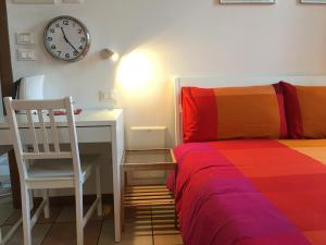 a bedroom with a bed and a desk and a clock at Residence Villa Rendina in Mestre