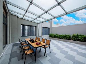 a dining room with a table and chairs on a patio at Park Inn by Radisson Zhuhai Gaolan Port in Nanshui