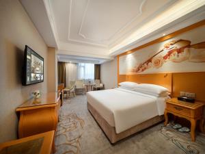 Vienna International Hotel Shenzhen Longhua Xiken tesisinde bir odada yatak veya yataklar