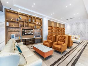 a living room with couches and chairs and shelves at Vienna International Hotel Chongqing Jiangbeizui Financial Center in Chongqing
