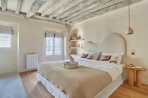 een slaapkamer met een groot wit bed in een kamer bij Apartment Place Vendome by Studio prestige in Parijs