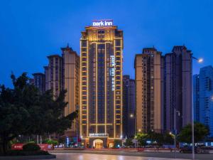 ein hohes Gebäude mit einem Schild darüber in der Unterkunft Park Inn by Radisson Beihai Silver Beach Wanda Plaza in Beihai