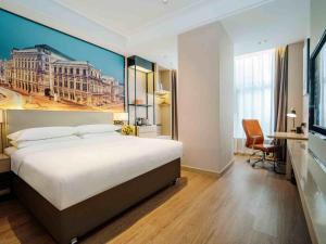 una camera da letto con un grande letto e un dipinto sul muro di Vienna International Hotel Wudu Gujinli Longnan a Longnan