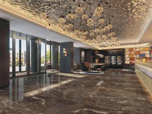 um lobby de um hotel com um lustre em Park Inn by Radisson Jilin Beishan Park&Songhua River em Jilin