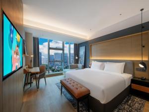 成都市にあるPark Inn by Radisson Chengdu Sihe Metro Station Xinchuanの大型ベッド1台、薄型テレビが備わるホテルルームです。