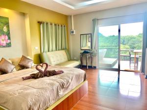 a hotel room with a bed and a balcony at Kwainoy Riverpark in Sai Yok