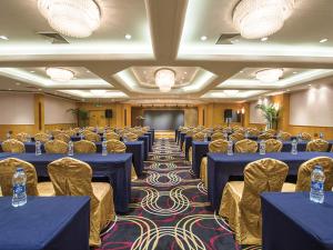 una sala de conferencias con mesas azules y sillas doradas en Park Inn by Radisson Shanghai Downtown en Shanghái