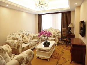 een woonkamer met banken en een tafel met bloemen bij Vienna International Hotel Shanghai Hongqiao Airport Convention and Exhibition Center Huaxu Highway in Qingpu