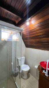 uma casa de banho com um WC e uma cabina de duche em vidro. em Chalé em Bombinhas/Porto belo em Porto Belo