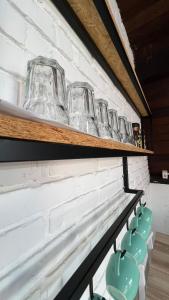 uma fila de copos numa prateleira numa parede em Chalé em Bombinhas/Porto belo em Porto Belo