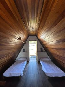 um quarto com 2 camas num chalé de madeira em Chalé em Bombinhas/Porto belo em Porto Belo