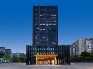 Um edifício alto e preto com um portão à frente. em Vienna International Hotel Chongqing Jiangbeizui Financial Center em Chongqing