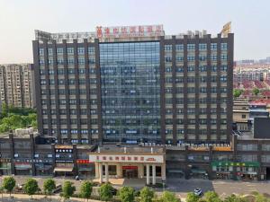 um grande edifício com uma loja em frente em Vienna International Hotel Shanghai Hongqiao International Exhibition Center Aite Road em Jiading