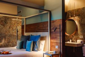 una camera da letto con letto, cuscini blu e specchio di Albergo La Pace a Segni