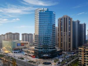 a tall building with a sign on it in a city at Park Inn by Radisson Nanchong Yilong Star City Plaza in Yilong