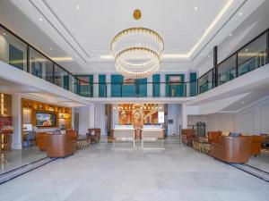 a large lobby with chairs and a chandelier at Vienna International Hotel Kunming longquan road Finance University in Kunming