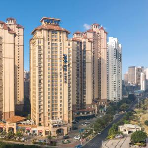 a group of tall buildings in a city at Park Inn by Radisson Beihai Silver Beach Wanda Plaza in Beihai