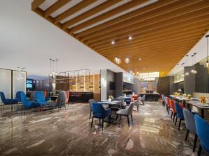 a restaurant with blue chairs and tables in a room at Park Inn by Radisson Chengdu Wuhou Shrine in Chengdu