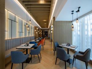 a row of tables and chairs in a restaurant at Park Inn by Radisson Shaoxing China Keqiao in Shaoxing