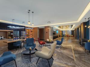 a waiting area in a hospital with chairs and tables at Park Inn by Radisson Shandong Yucheng High-tech Zone Detpak Plaza in Yucheng