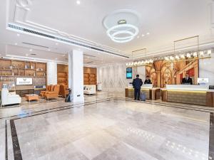 a man standing in the lobby of a building at Vienna International Hotel Chongqing Jiangbeizui Financial Center in Chongqing